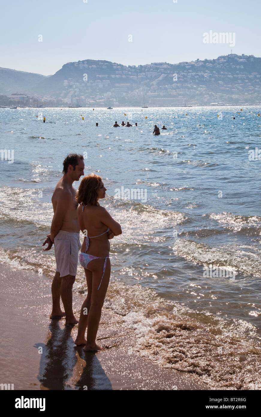 Couple at water's edge Playa de Roses beach Emporda Catalunya Spain Stock Photo