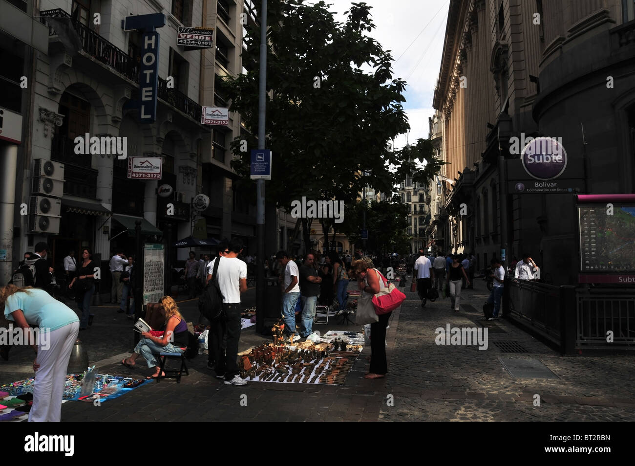 Urban view of shoppers and vendors at a craft market laid out on sheets in the middle of the walkway, Peru Street, Buenos Aires Stock Photo