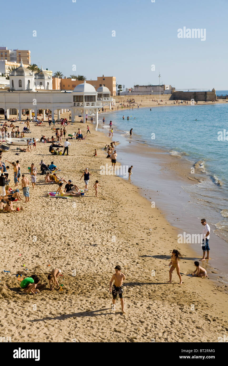 Tourists enjoy themselves on the sandy Spanish beach at Cadiz. Spain. Stock Photo