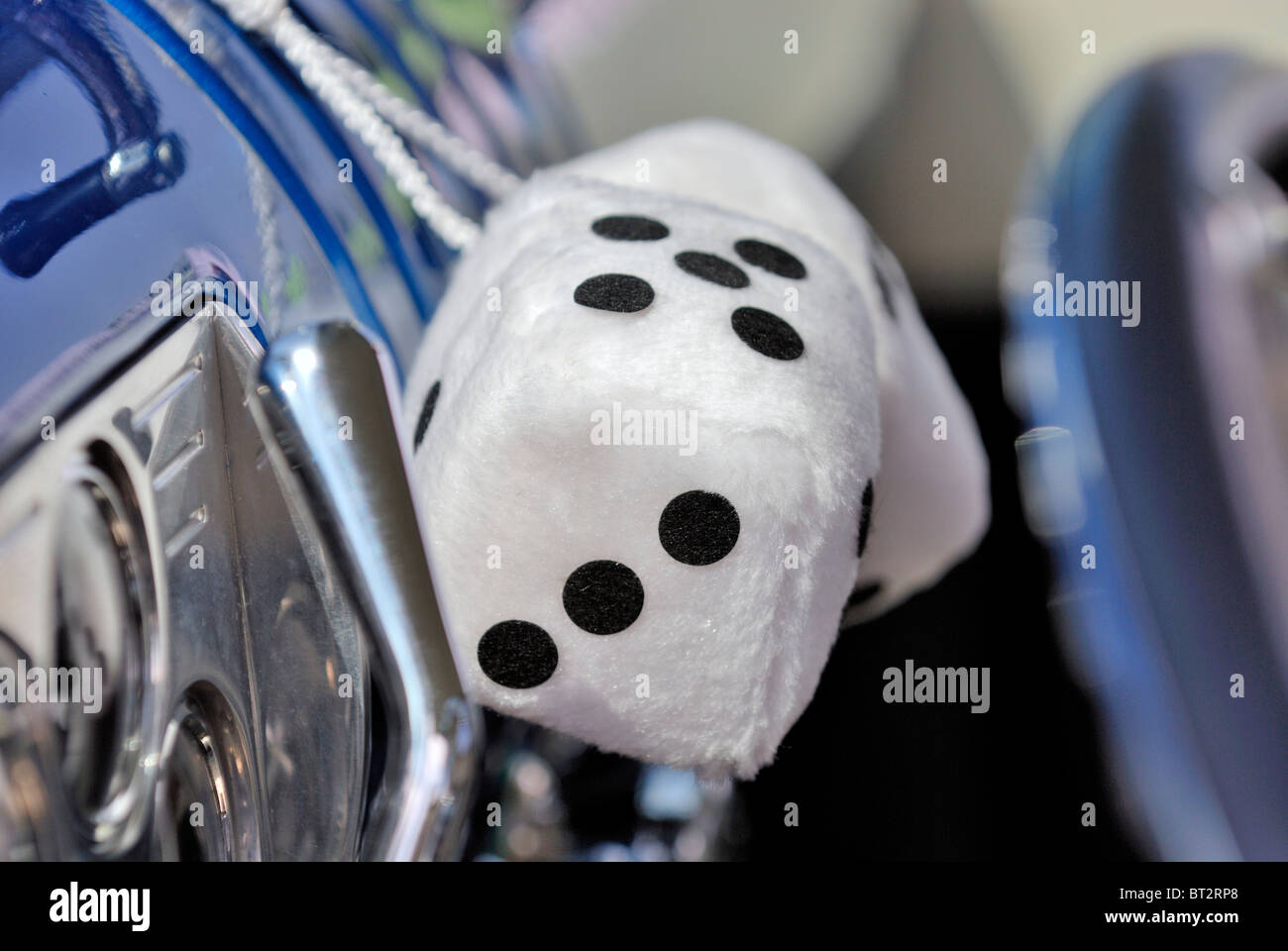 Large white dice with the number adding up to eight, hanging on the dashboard of a classic car. Stock Photo