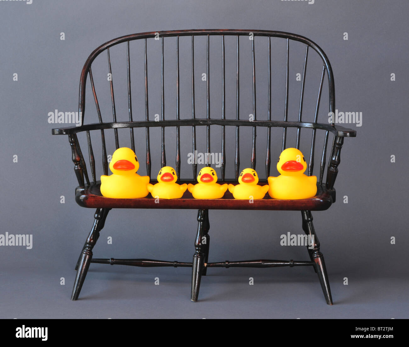 Little yellow rubber duckies setting in a chair. Stock Photo
