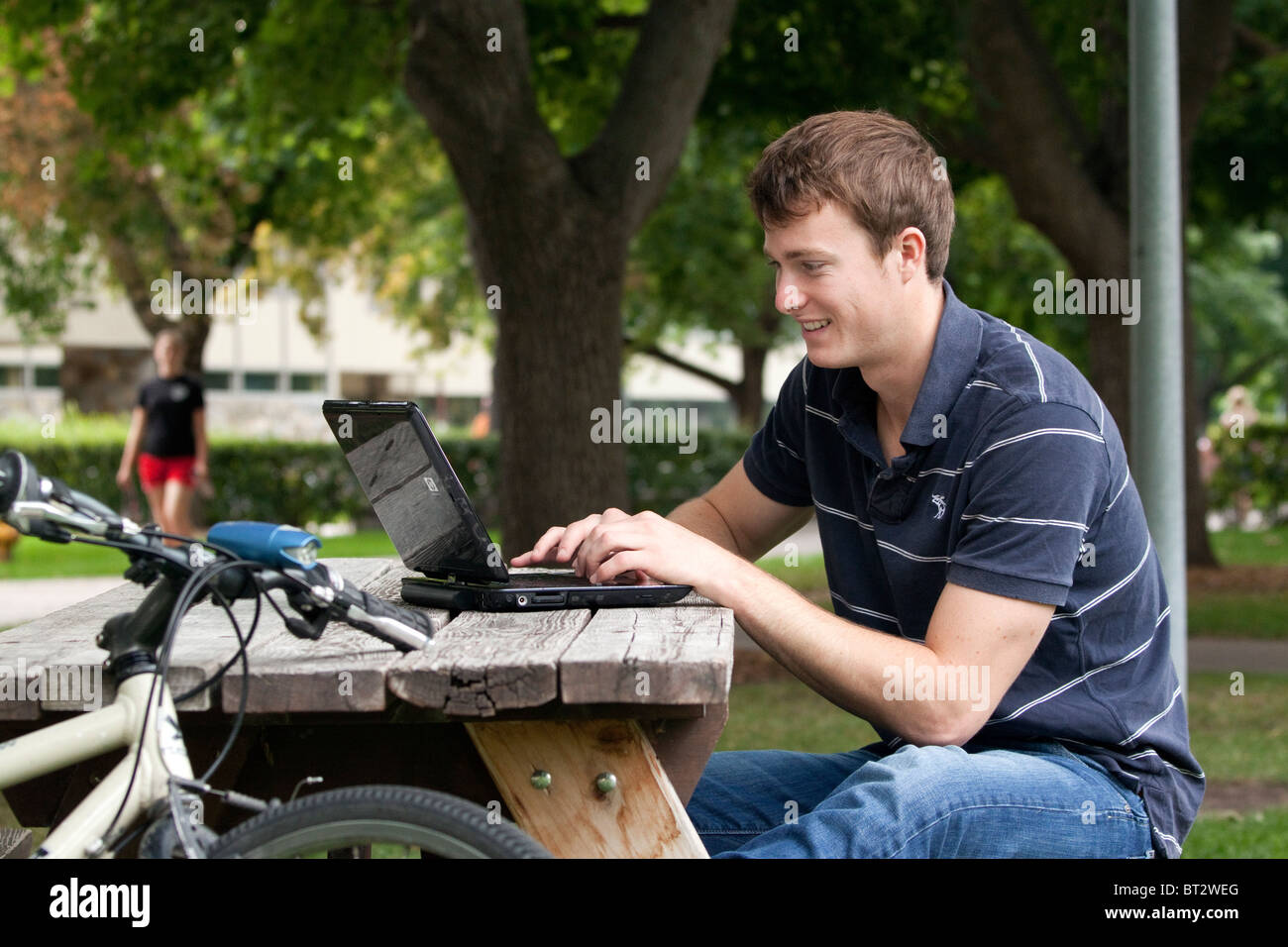 Young man in his twenties using a laptop computer outdoors Stock Photo ...