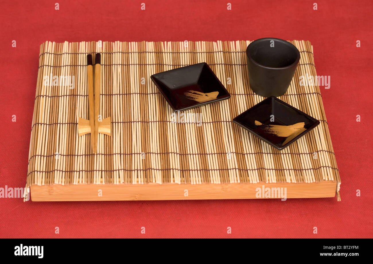 Still life from tray with chinese stick's and sauce-boat on red Stock Photo