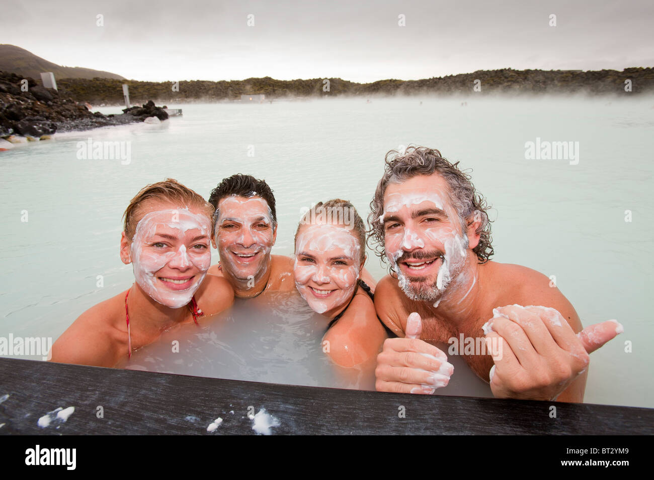 Four friends relax at the Blue Lagoon near at Keflavik in Iceland. Stock Photo