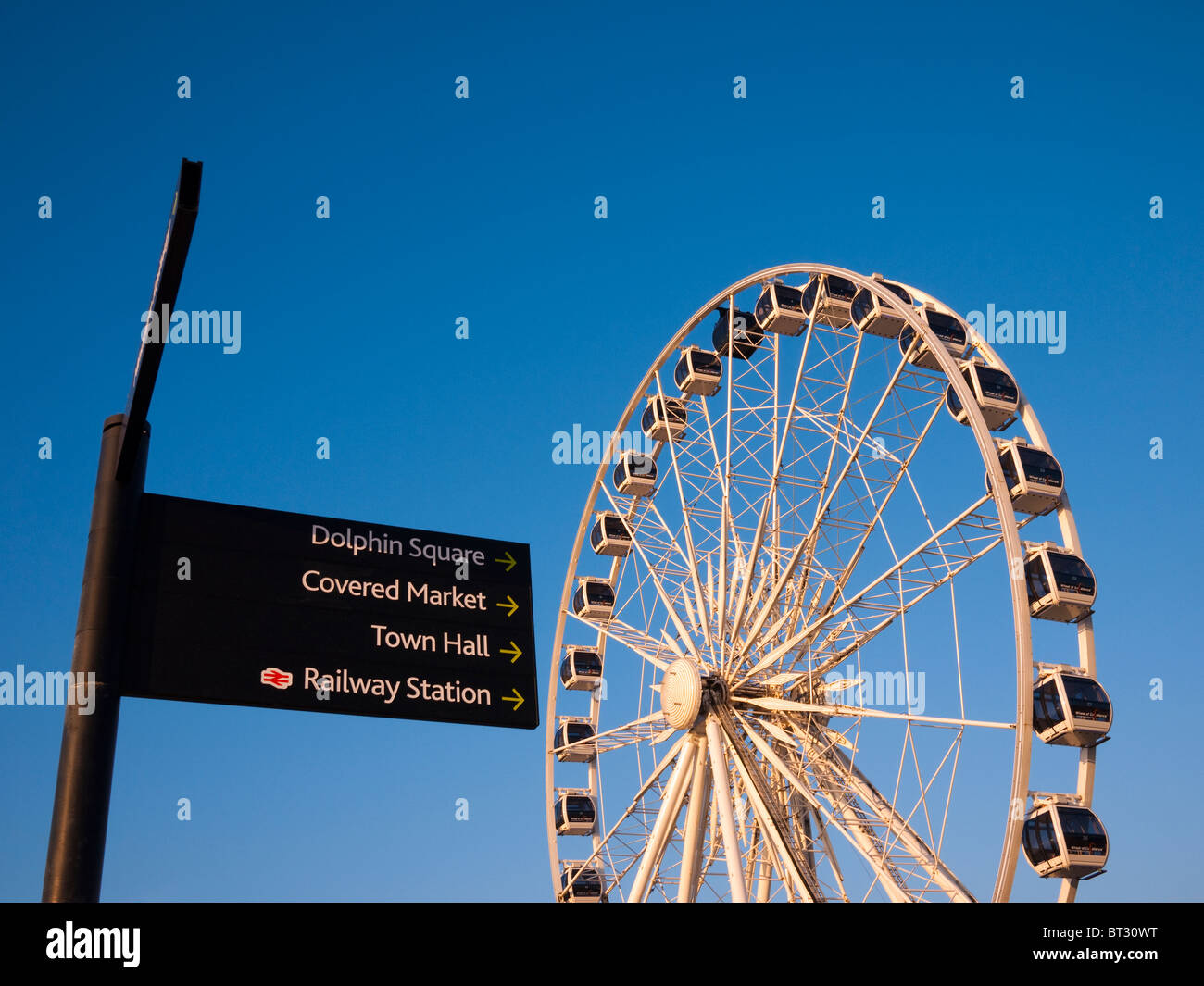 The Wheel of Weston and signpost on the seafront of Weston-super-Mare at sunset, North Somerset, England. Stock Photo