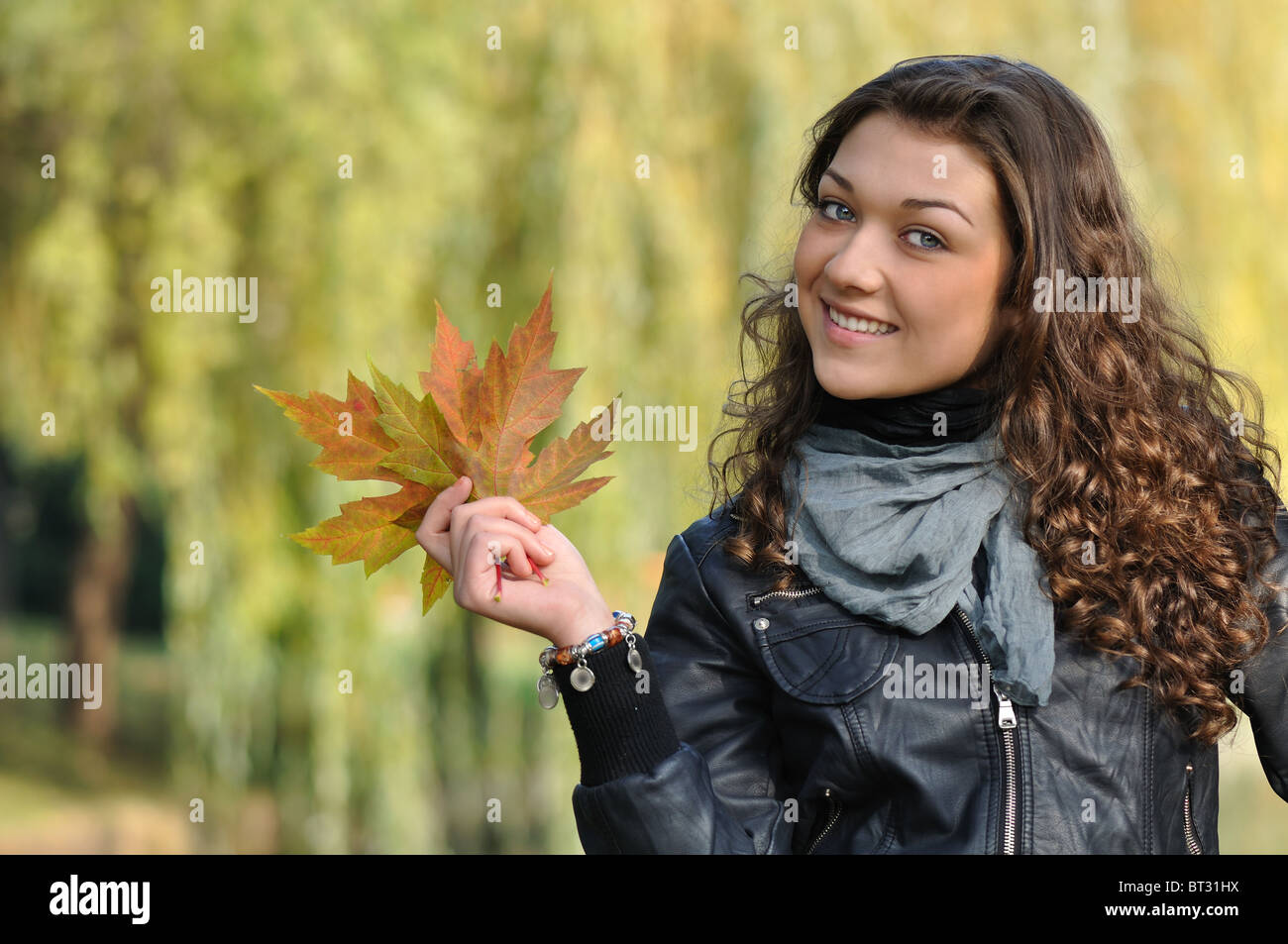 happy young woman showing beautiful maple leaves Stock Photo - Alamy