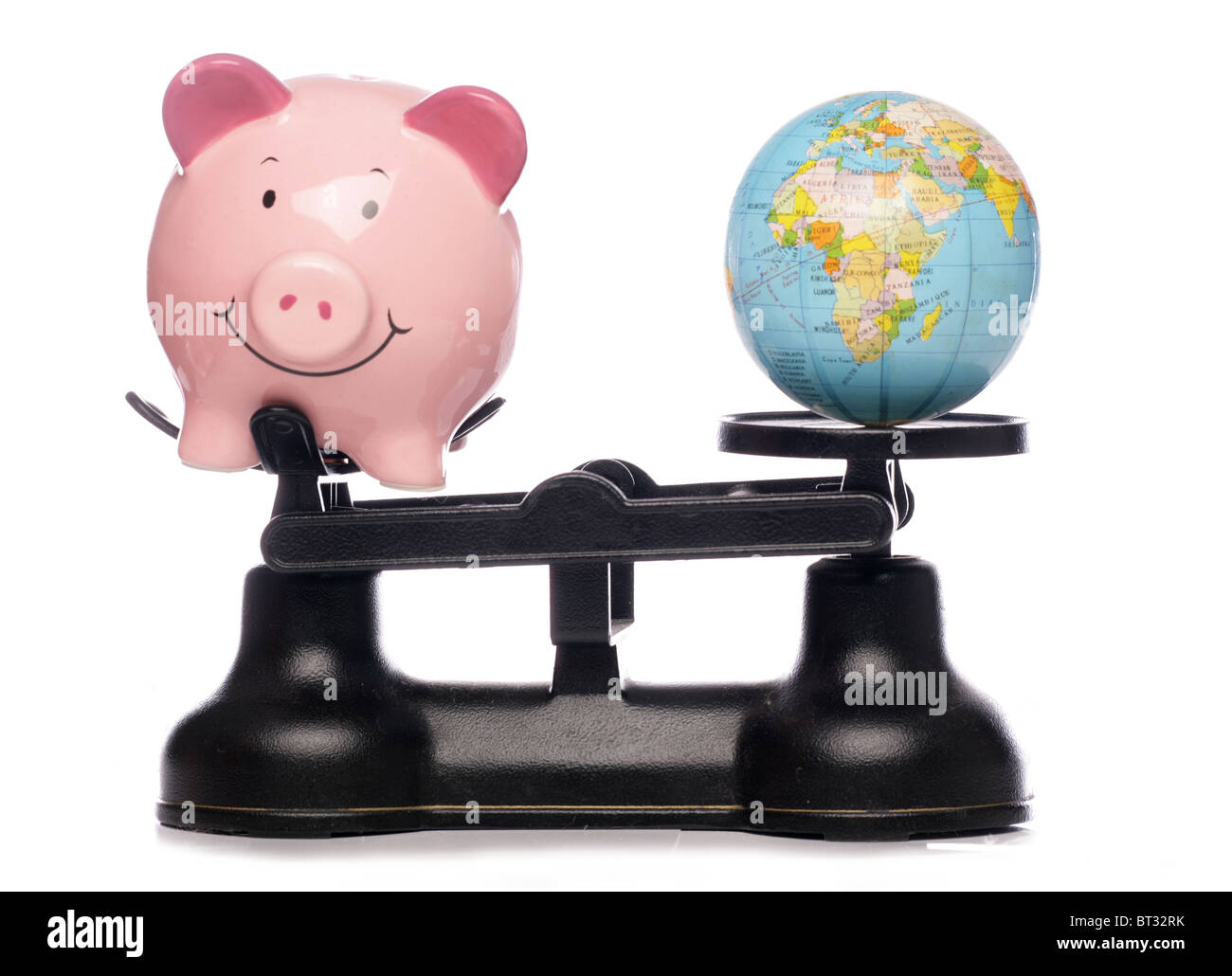 Piggybank and globe on scales studio cutout Stock Photo