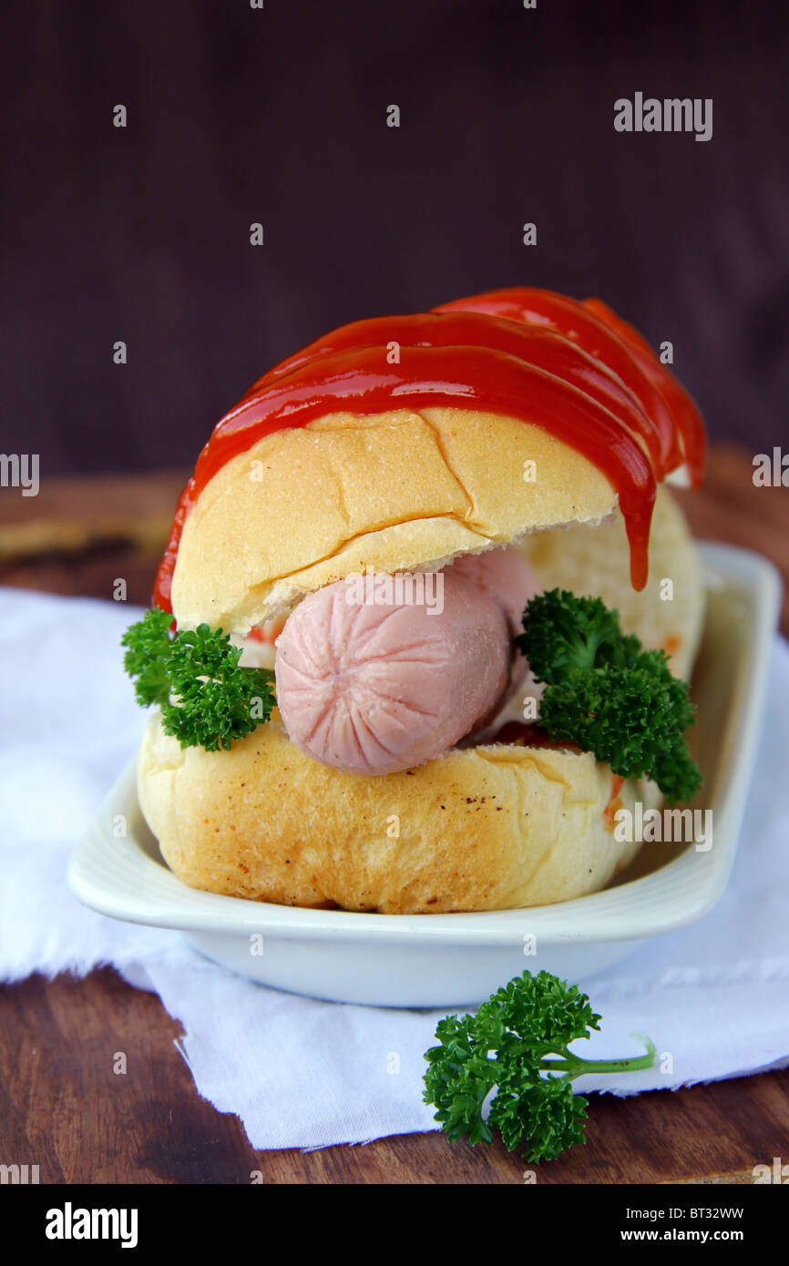 Hotdog on a plate on a brown wooden desk Stock Photo
