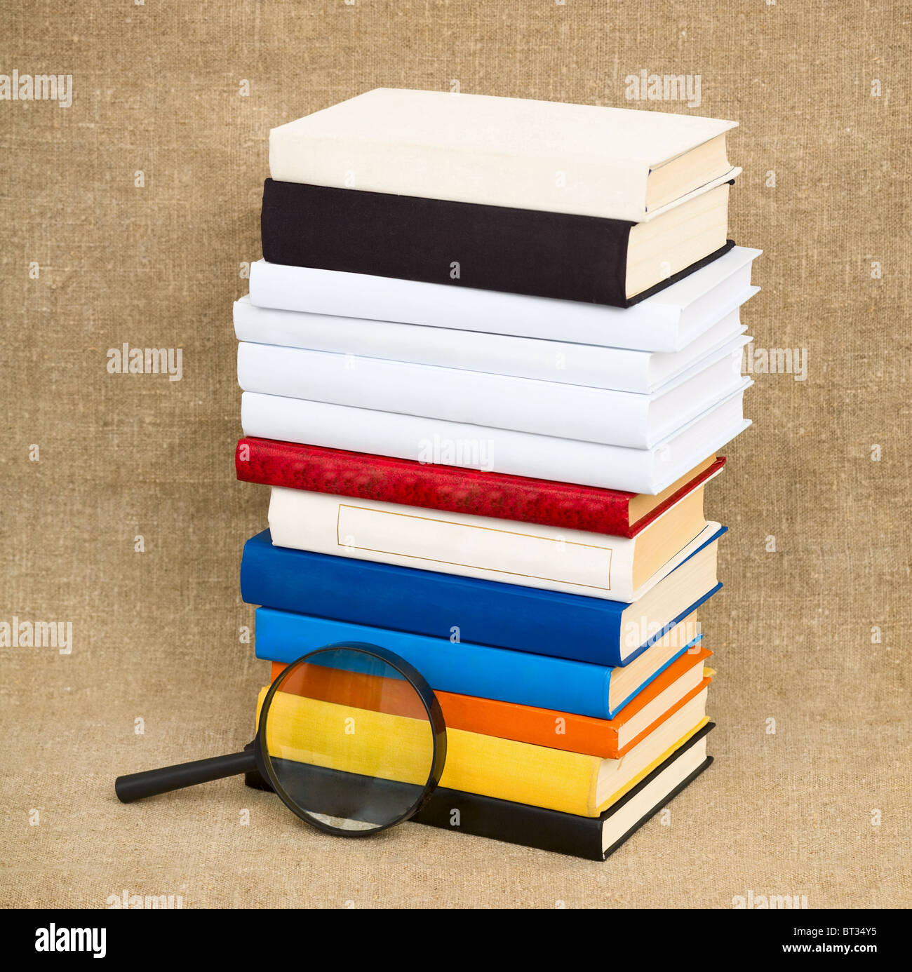 Books and magnifying glass on the fabric background Stock Photo