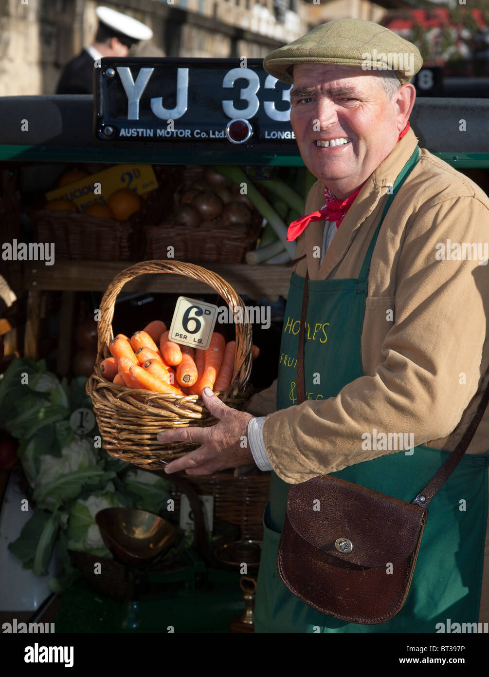 Greengrocer selling carrots   Holding basket, priced in pre-decimal currency at Wartime Weekend, Picking, October, 2010 Stock Photo