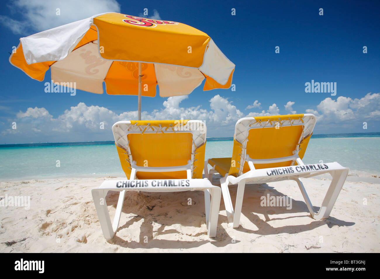 Yellow parasol and loungers on the beach at Playa Norte on Isla Mujeres in Mexico Stock Photo