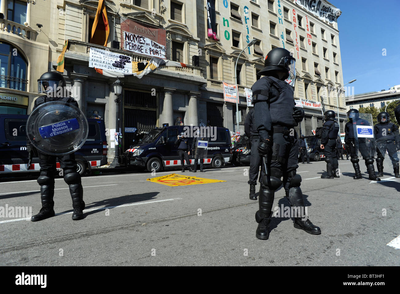 Riot police keeping a building at Barcelona city centre that have been occupied by squatters day's before the general strike Stock Photo