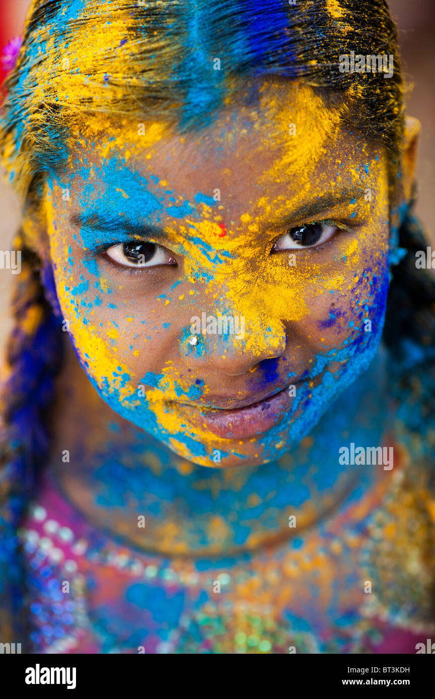 Young Indian girl covered in coloured powder pigment. India Stock Photo