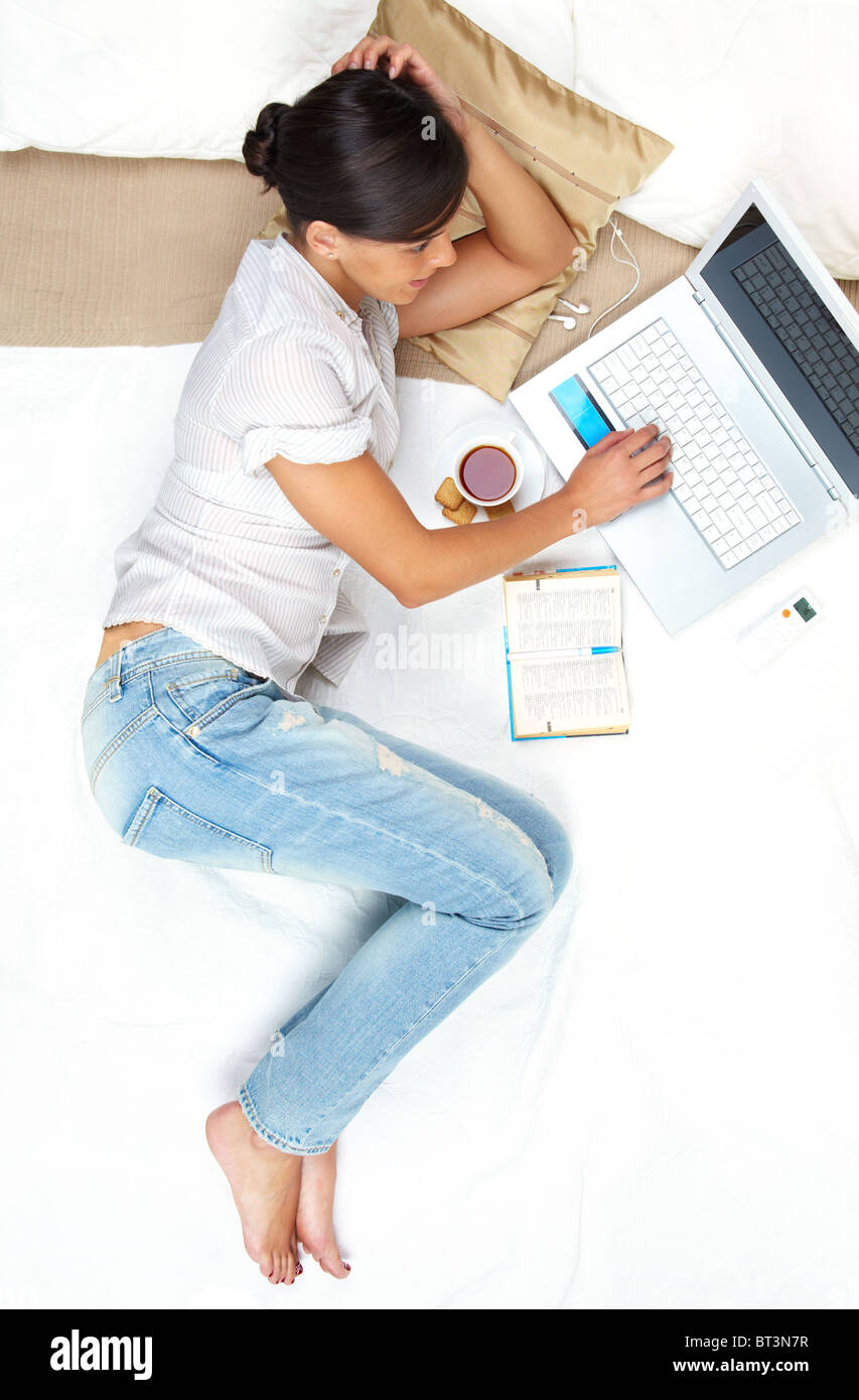 A young girl working on computer in bed Stock Photo Alamy