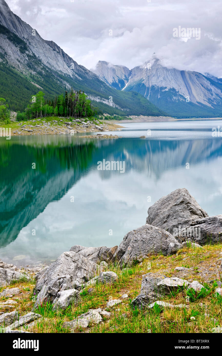 Mountains reflecting in Medicine Lake in Jasper National Park, Canada Stock Photo