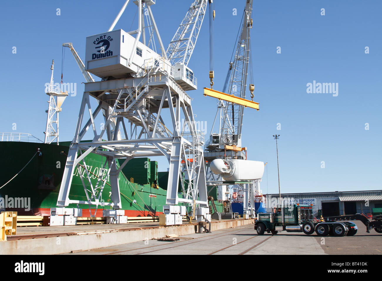 a wind turbine motor is being unloaded from a ship onto a semi at a port in Duluth,Minnesota Stock Photo