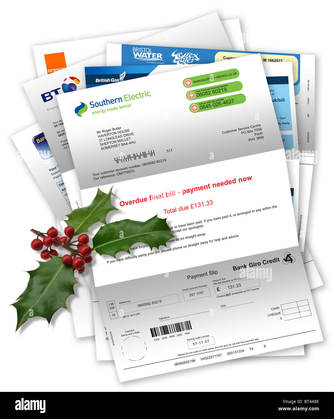 Household and credit card bills with with final demand and Christmas holly Stock Photo