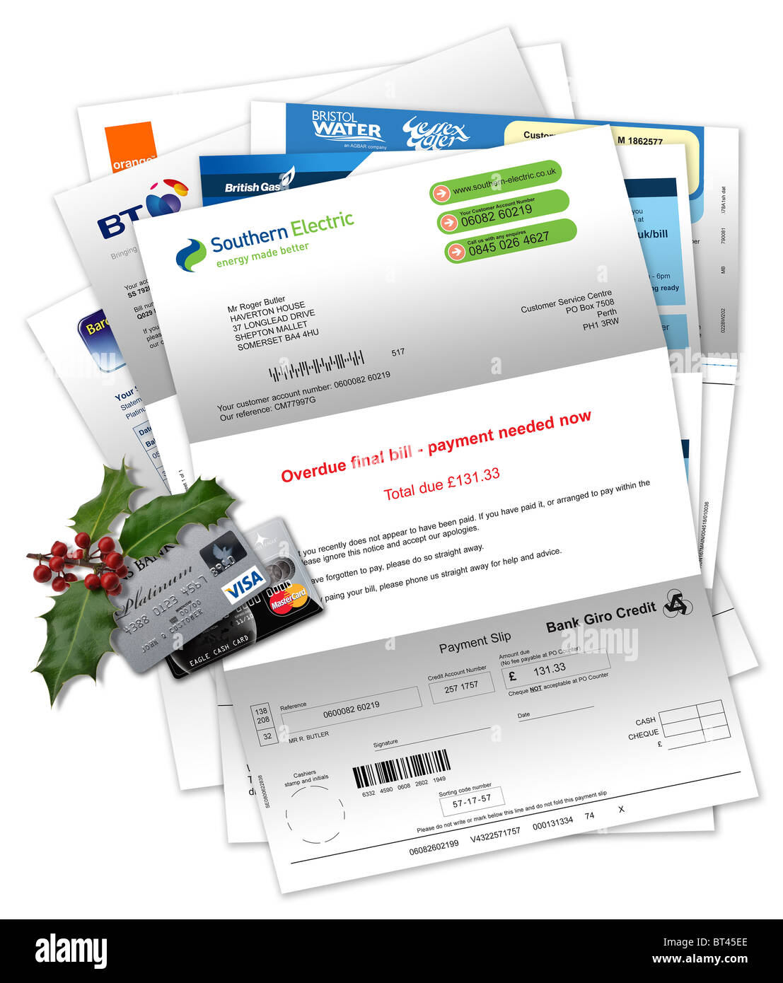 Household and credit card bills with credit cards and Christmas holly Stock Photo