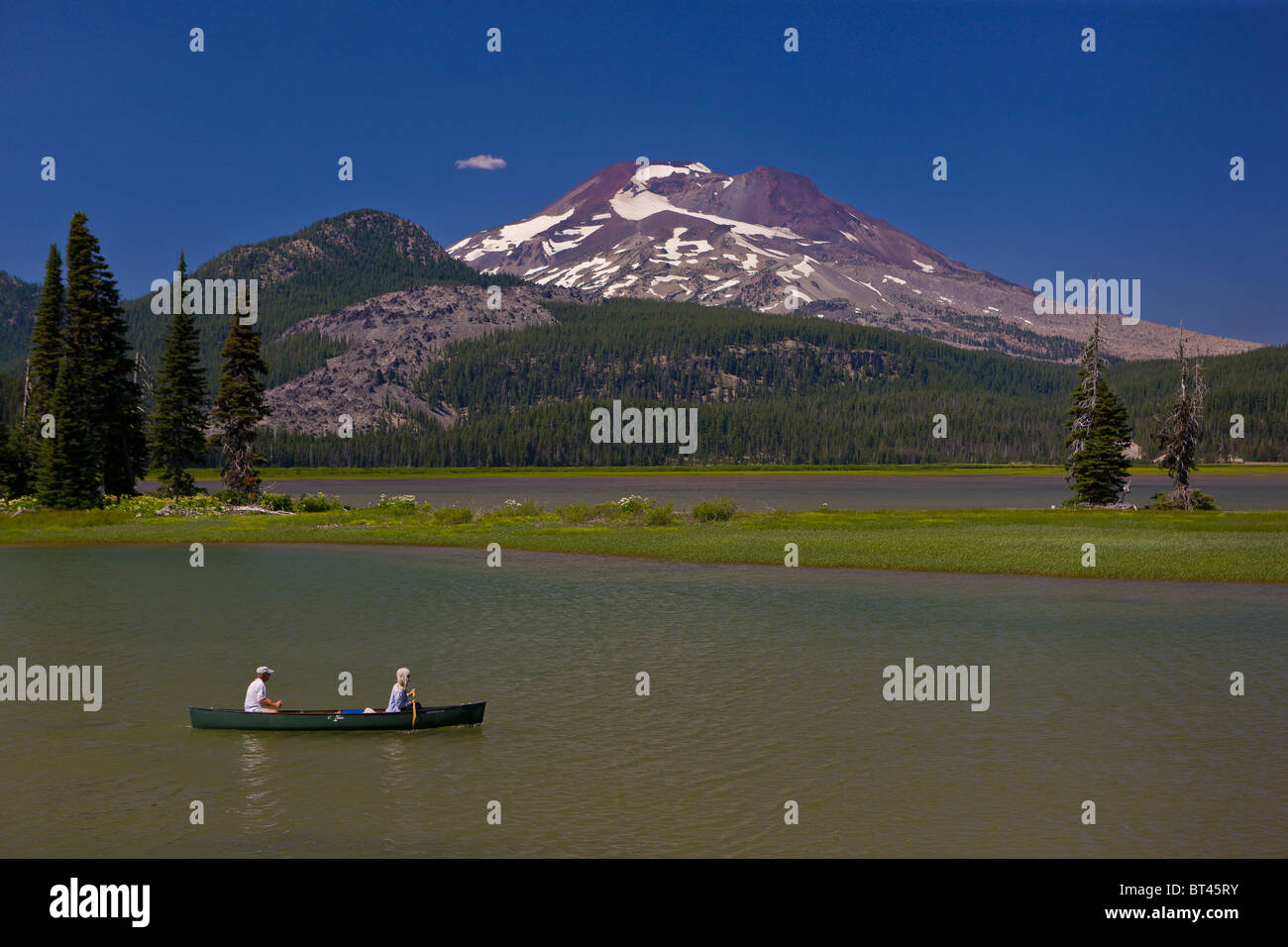 SPARKS LAKE, OREGON, USA - People in canoe on lake, South Sister, a volcano in the Cascades mountains of Central Oregon. Stock Photo