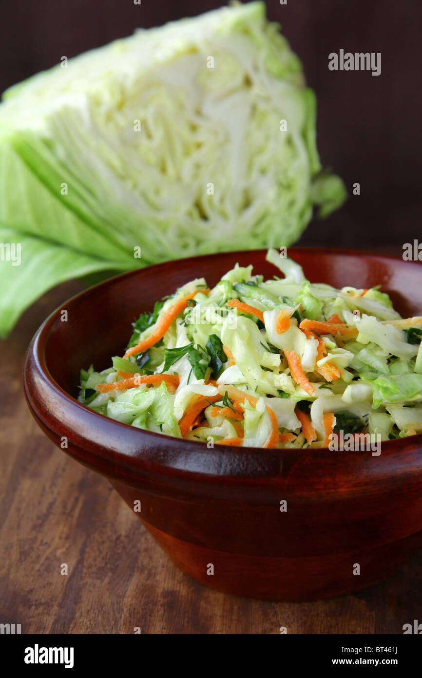 Coleslaw salad in white bowl on a brown background Stock Photo