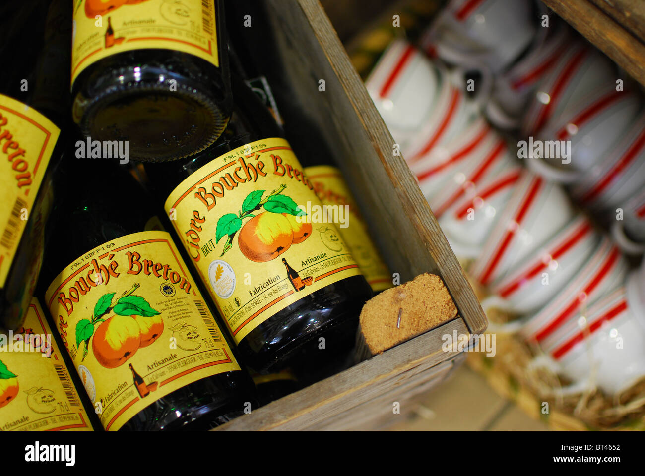 Bottles of Breton cider and traditional cider cups for sale in Brittany