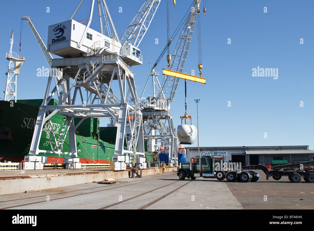 a wind turbine motor is being unloaded from a ship onto a semi at a port in Duluth,Minnesota Stock Photo
