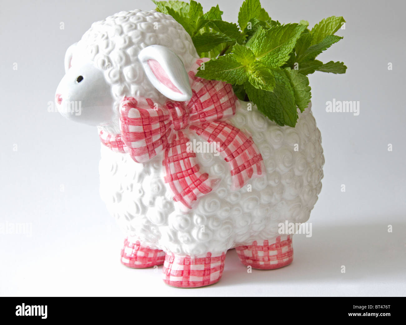 Plant pot in the shape of a lamb with sprigs of mint growing in it Stock Photo