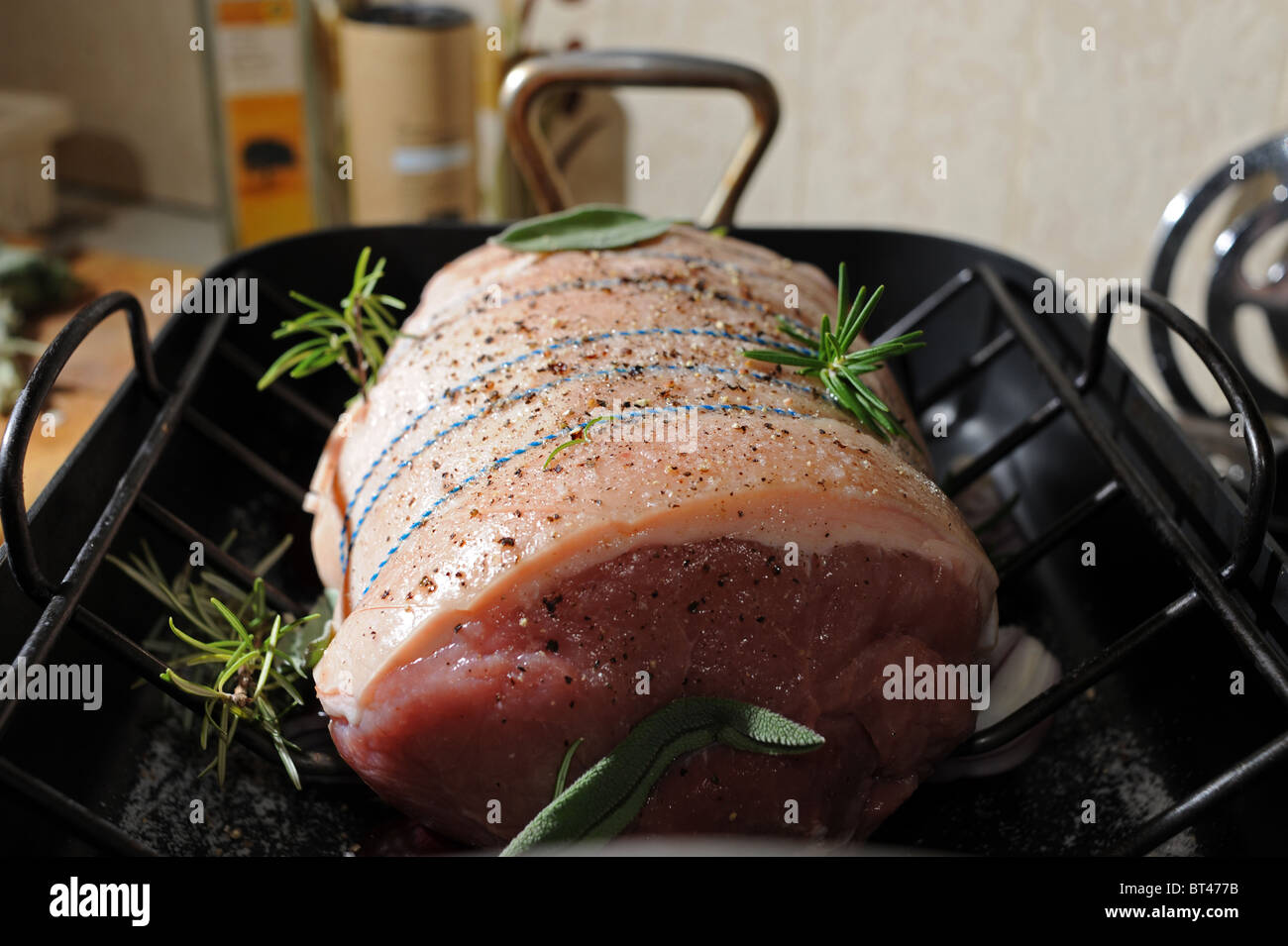 Joint of pork ready for roasting with sage and rosemary for Sunday