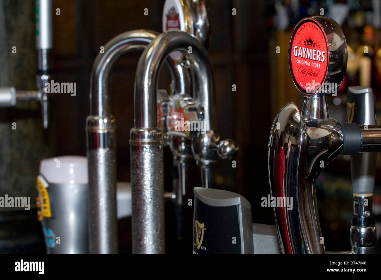 The pumps at a bar in the UK showing a range of alcoholic beverages from cider, lager and bitter. Stock Photo
