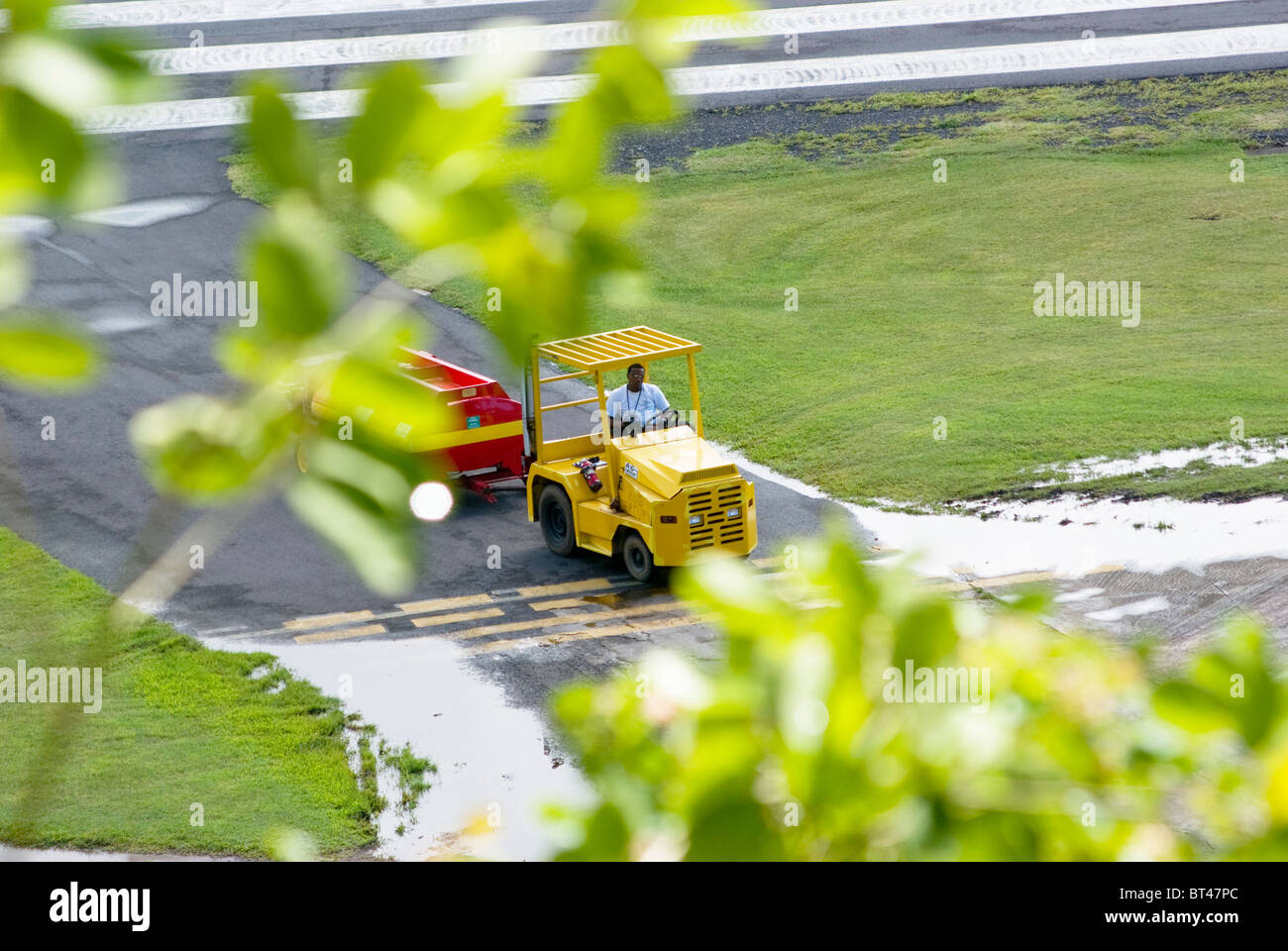 Airport employee driving motorized cart on Vigie Airport Saint Lucia. Stock Photo