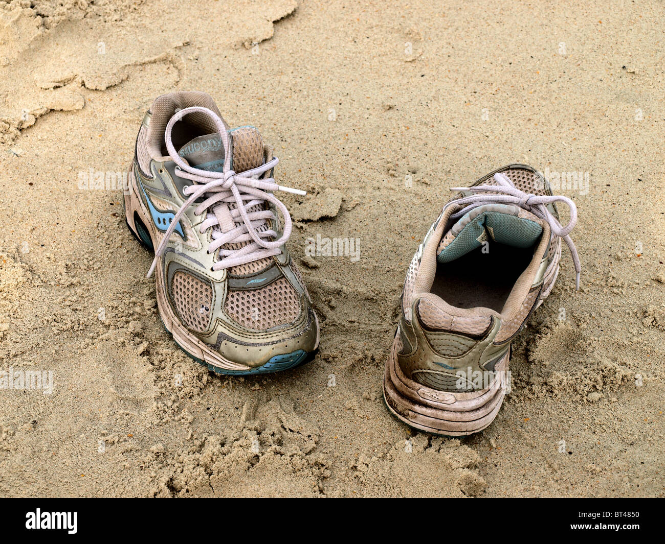 tennis walking sneakers shoes on sandy sand beach with shoestrings worn  Stock Photo - Alamy