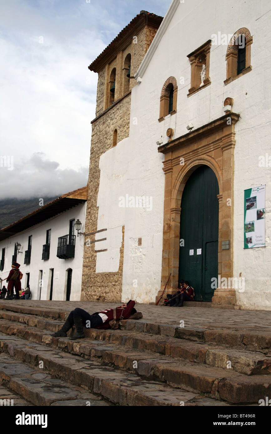 Soldiers sleeping in front of Iglesia Parroquial in Plaza Mayor in Villa de Leyva, Colombia Stock Photo