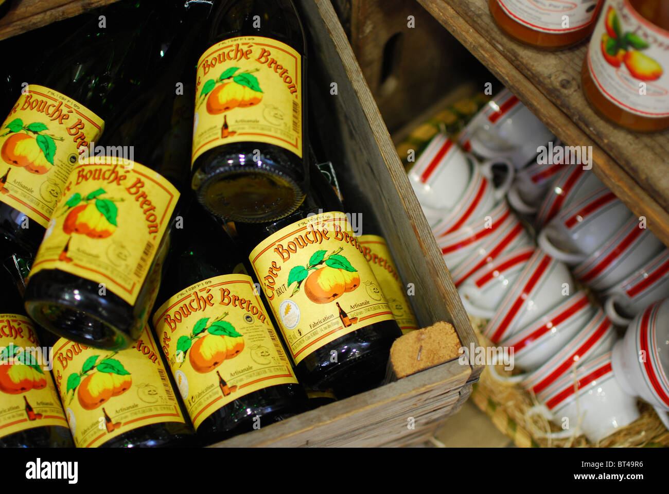 Bottles of Breton cider and traditional cider cups for sale in Brittany, France Stock Photo