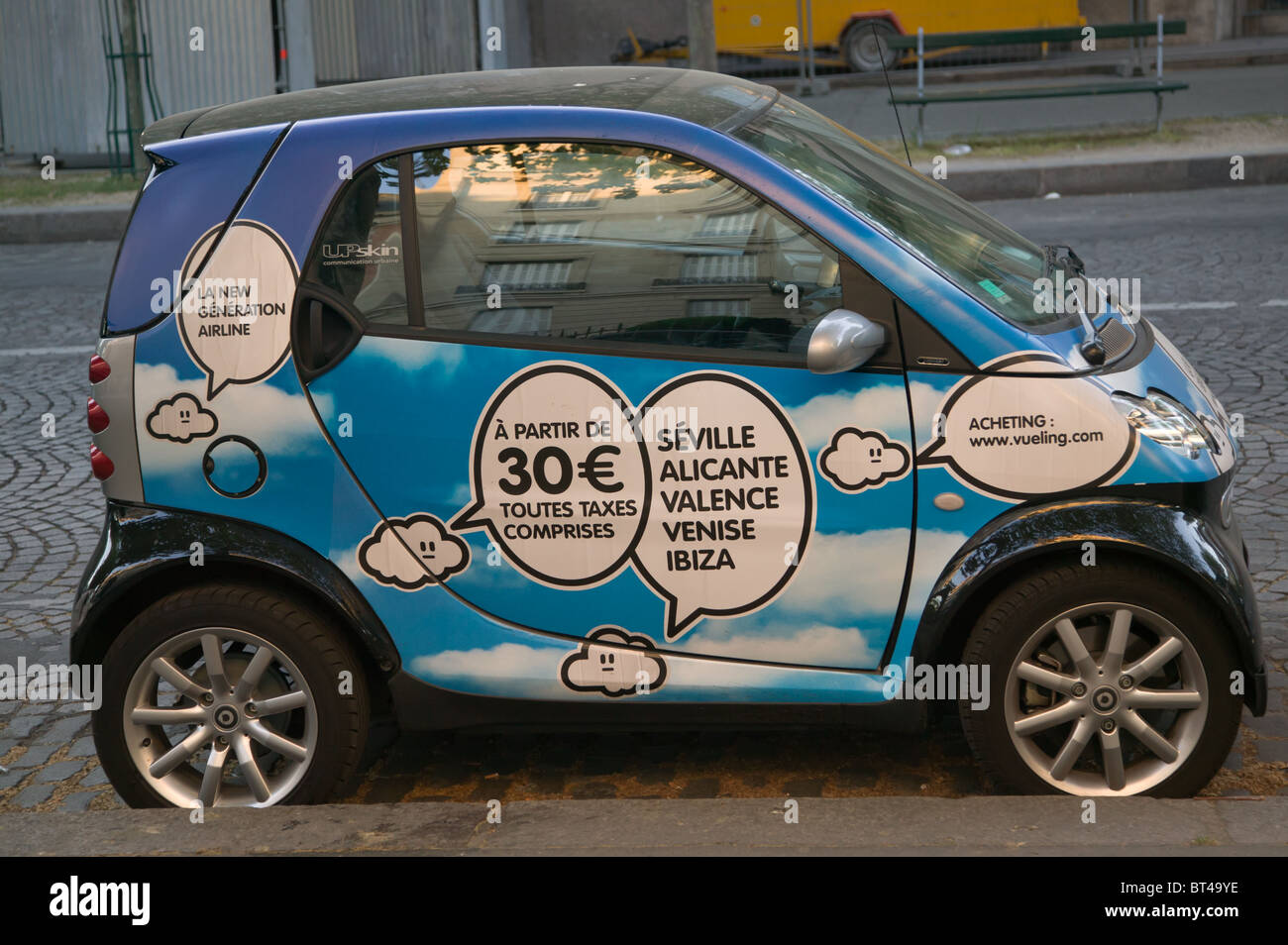 A Smart Car with advertising parked on the street in Paris, France Stock Photo