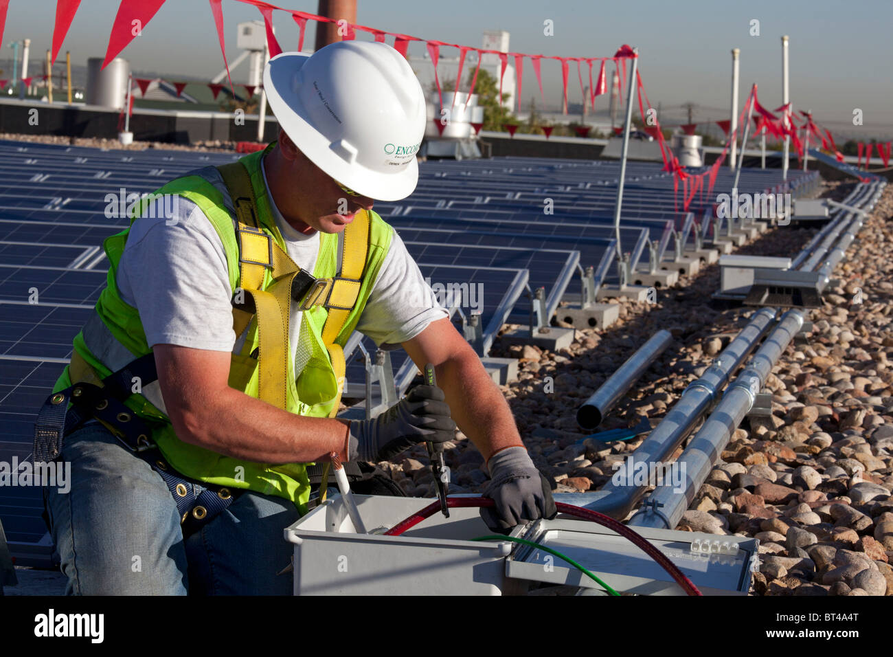 Denver, Colorado Workers install wiring for solar photovoltaic panels
