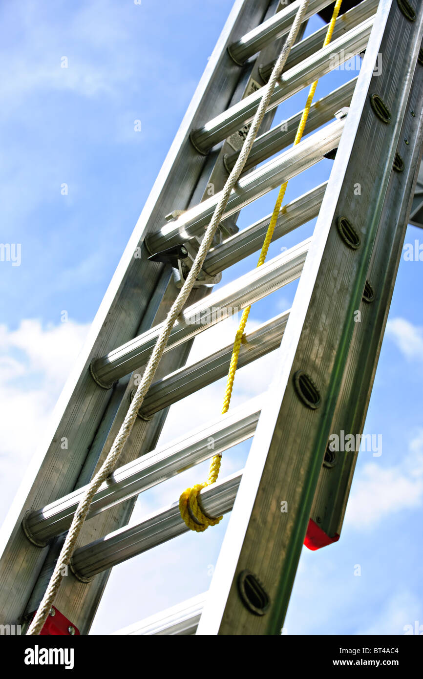 Closeup of construction aluminum extension ladder against blue sky Stock Photo
