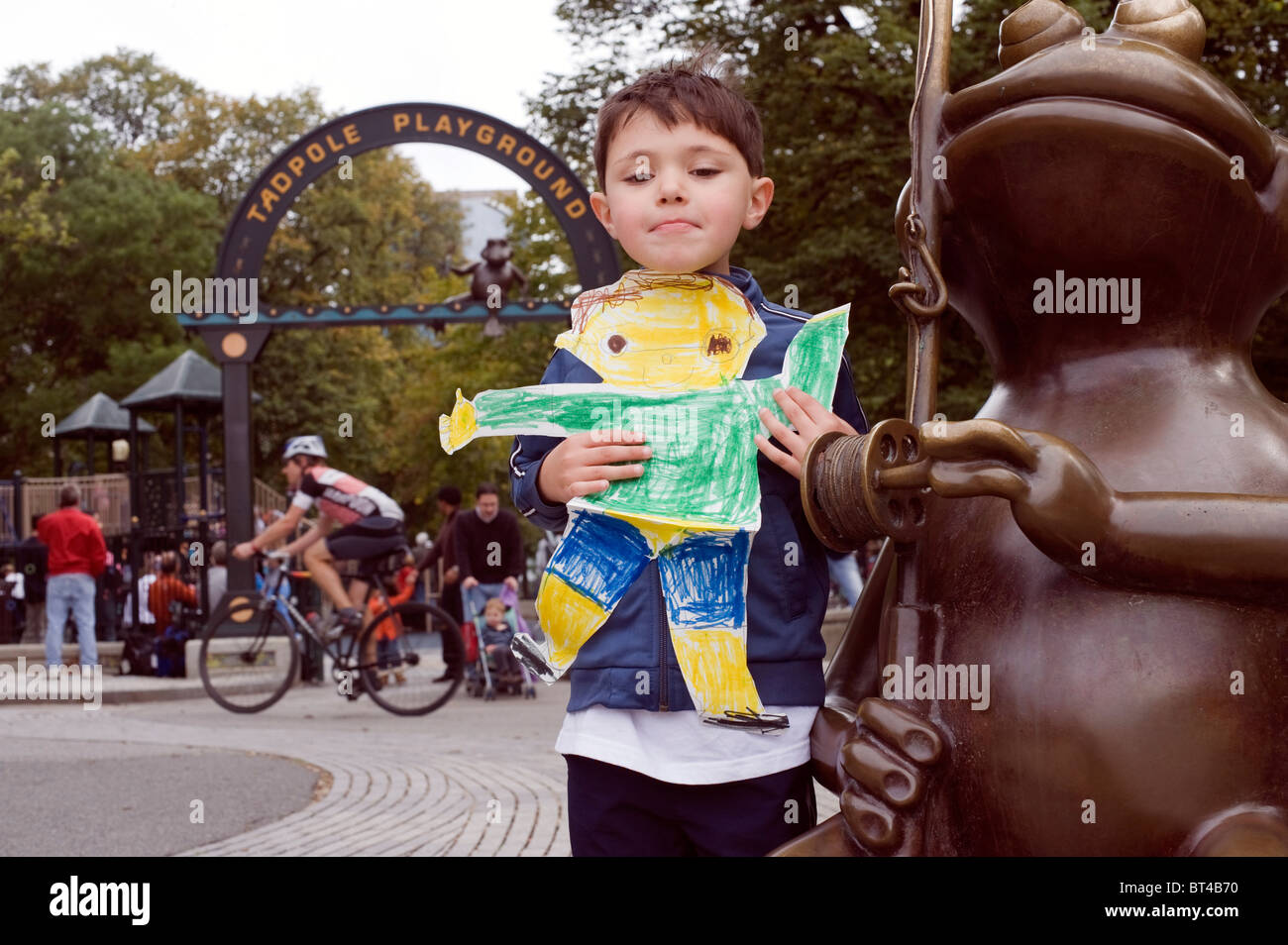Five year old boy holds up a 'Flat Stanley' drawing as part of a classroom assignment for his 4th grade cousin.  Boston Common Stock Photo