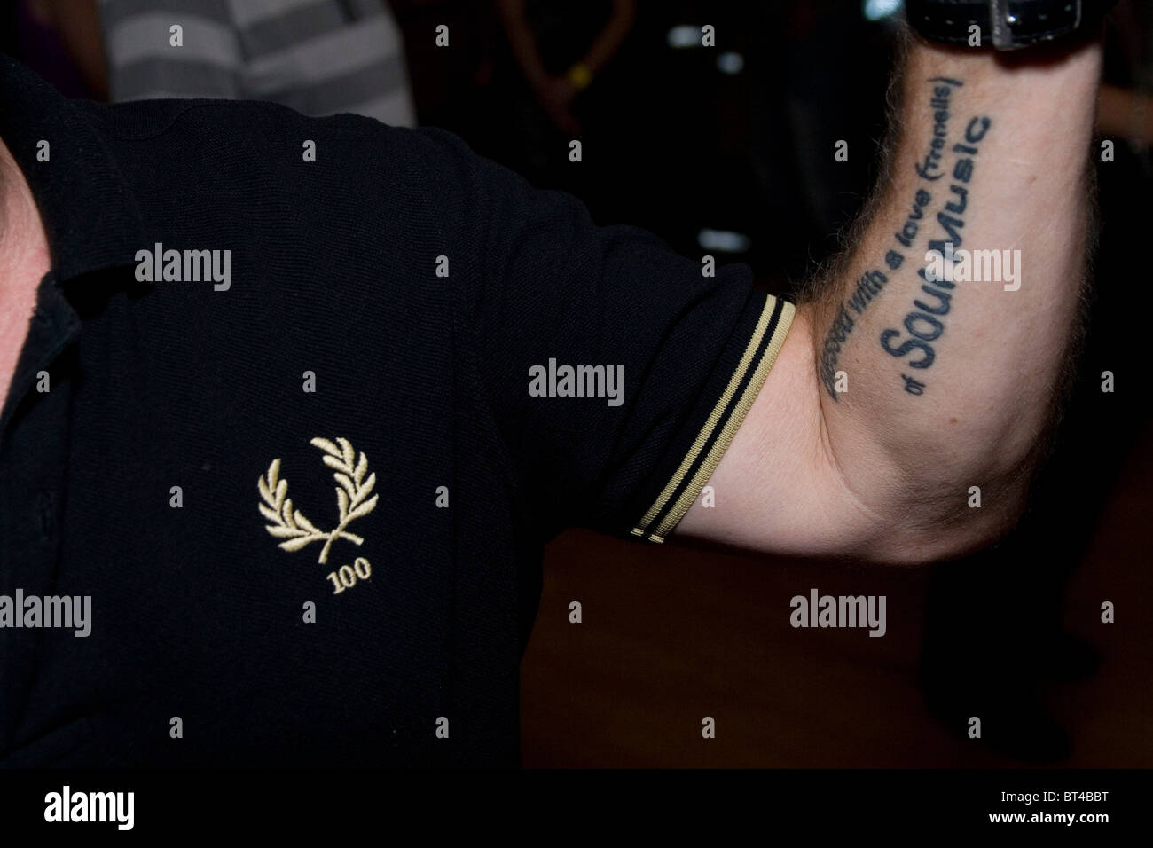 A man wearing a Fred Perry polo shirt synonymous with the Northern Soul and  Motown with his tattoo of his favourite song Stock Photo - Alamy