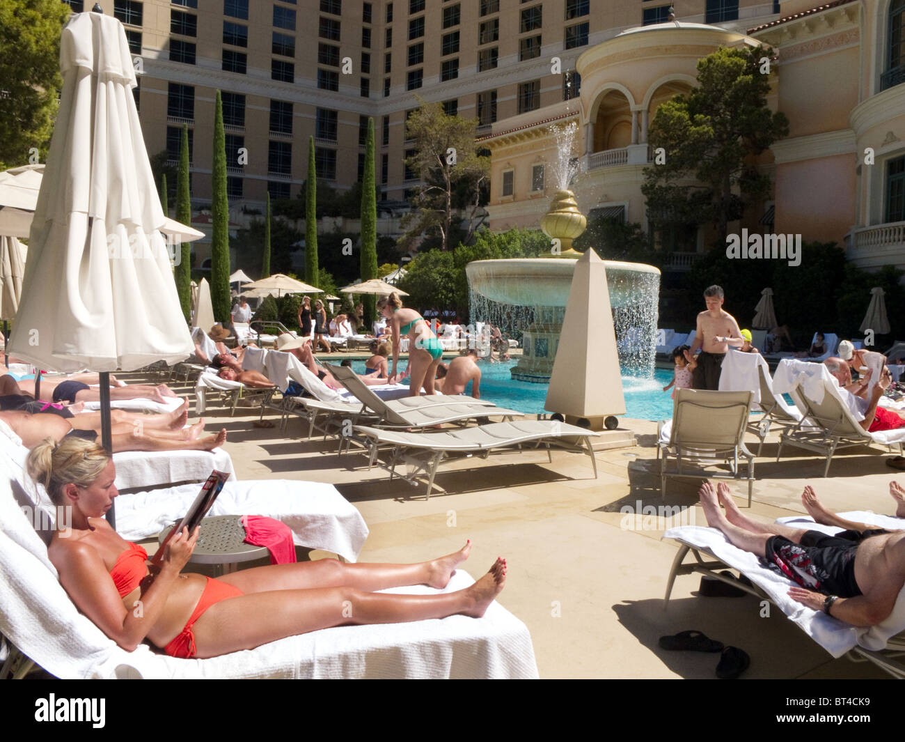 Tourists sunbathing by the swimming pool, the Bellagio Hotel, Las Vegas USA Stock Photo