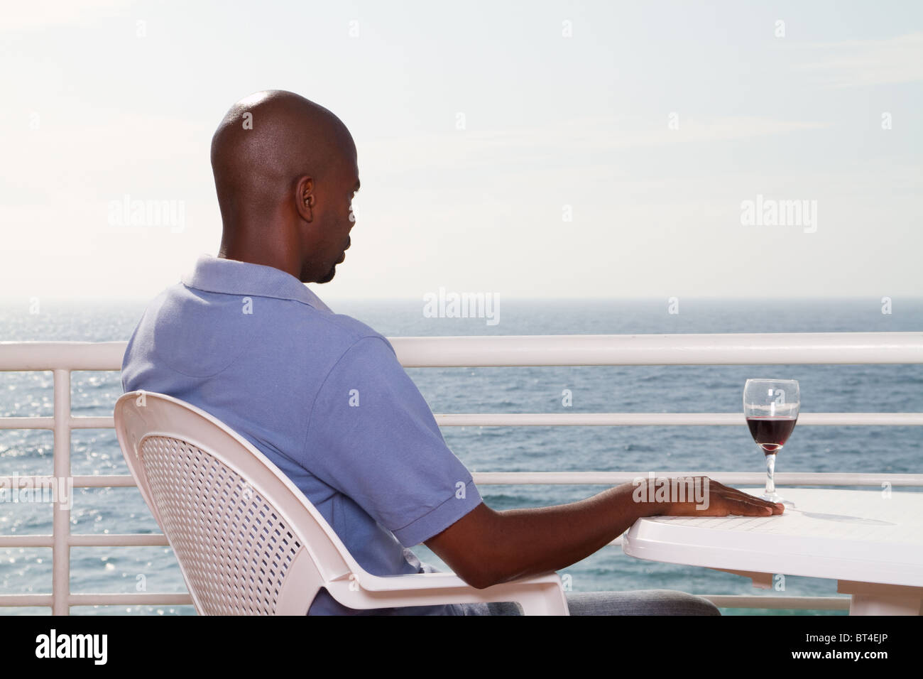 young african american man drinking wine on sea view balcony Stock ...