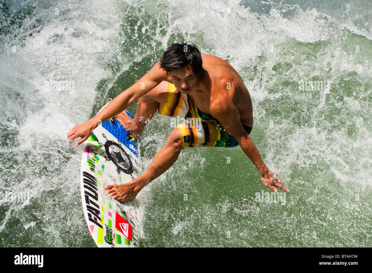 Surfer catching a wave on his board Stock Photo Alamy