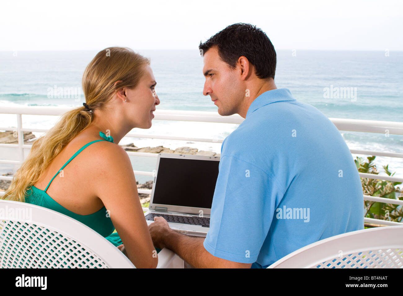 happy young couple using laptop on balcony Stock Photo - Alamy