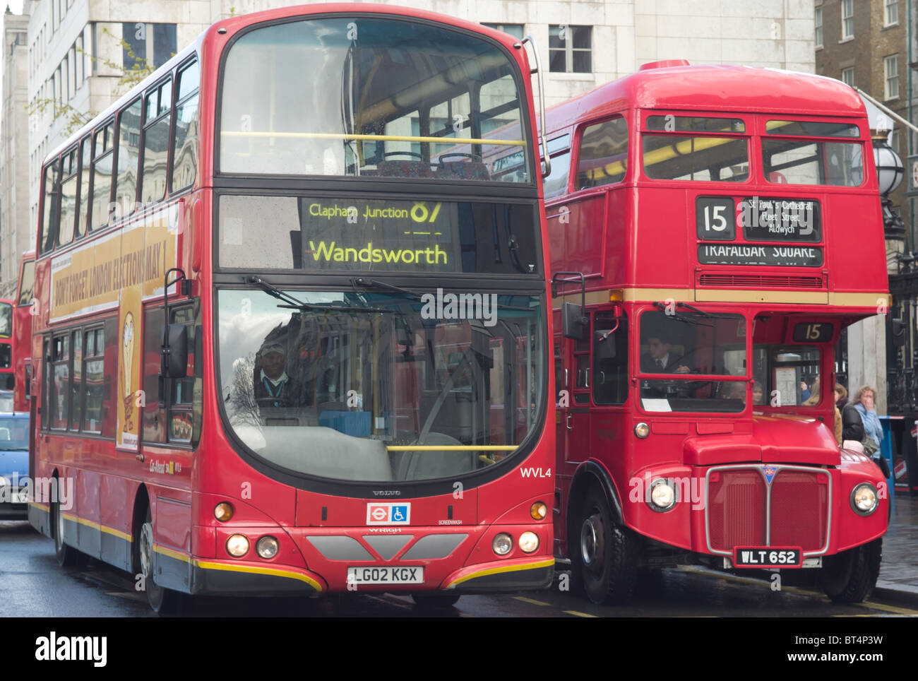 A Routemaster double decker bus operates on heritage route 15 next to a modern Go-Ahead bus in London, England, UK. Stock Photo