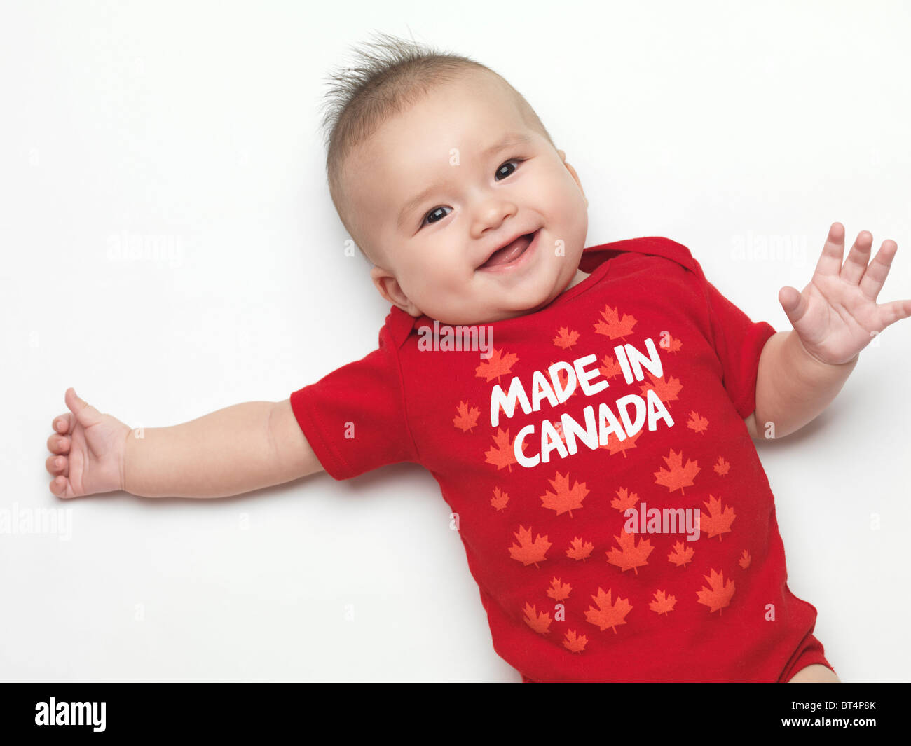 Happy smiling four month old baby boy wearing red Made in Canada body suit.  Isolated on white background Stock Photo - Alamy