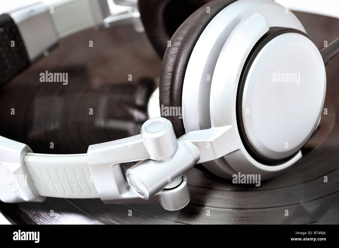 DJ headphones lying over black vinyl musical theme Stock Photo Alamy