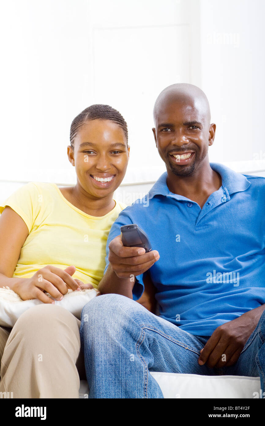 young happy african american couple watching TV on sofa Stock Photo - Alamy