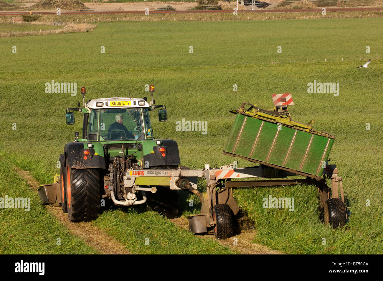 Mowing second cut grass with front and rear mounted mower conditioners