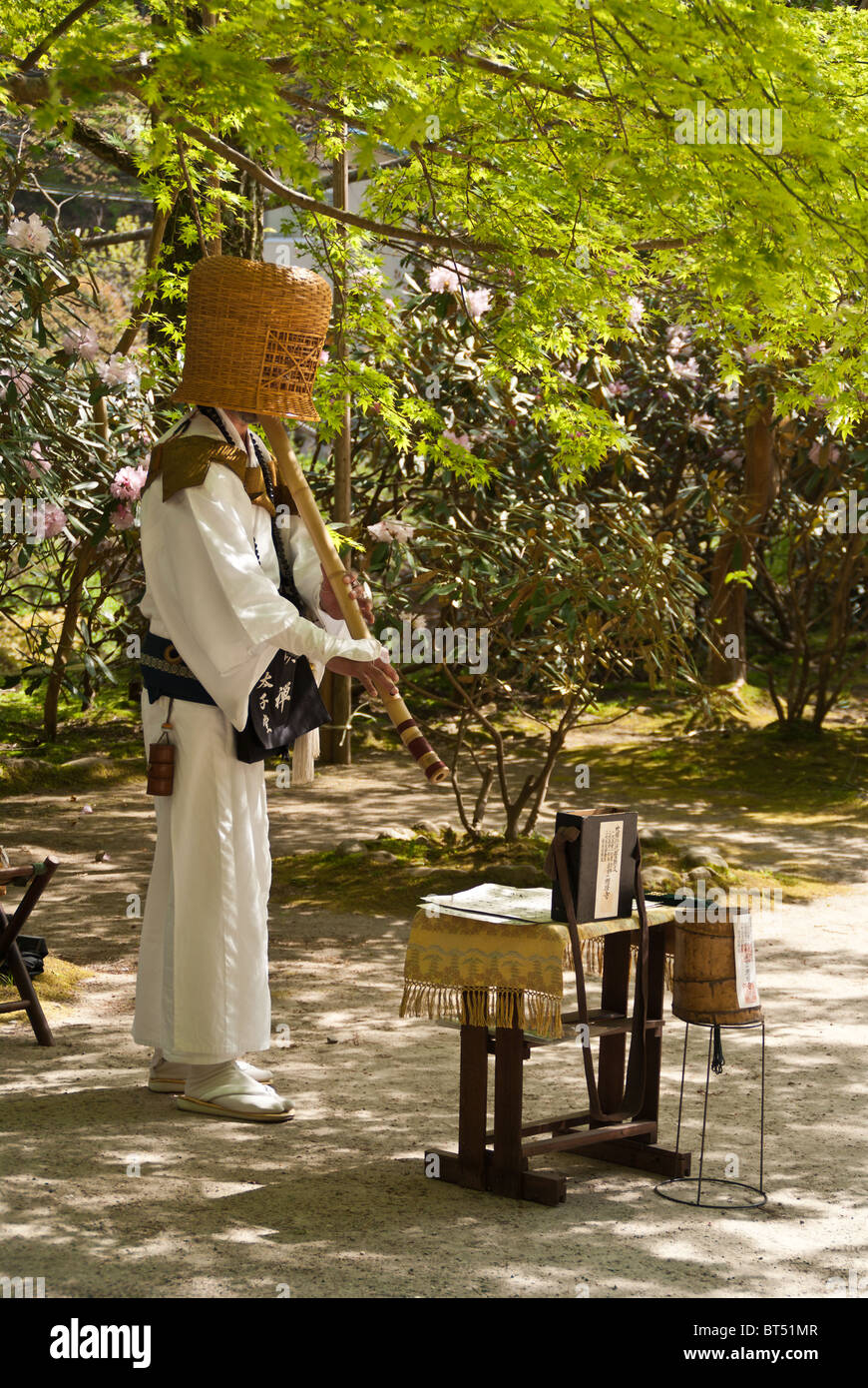 A buddhist monk playing a Japanese bamboo flute (shakuhachi) at a