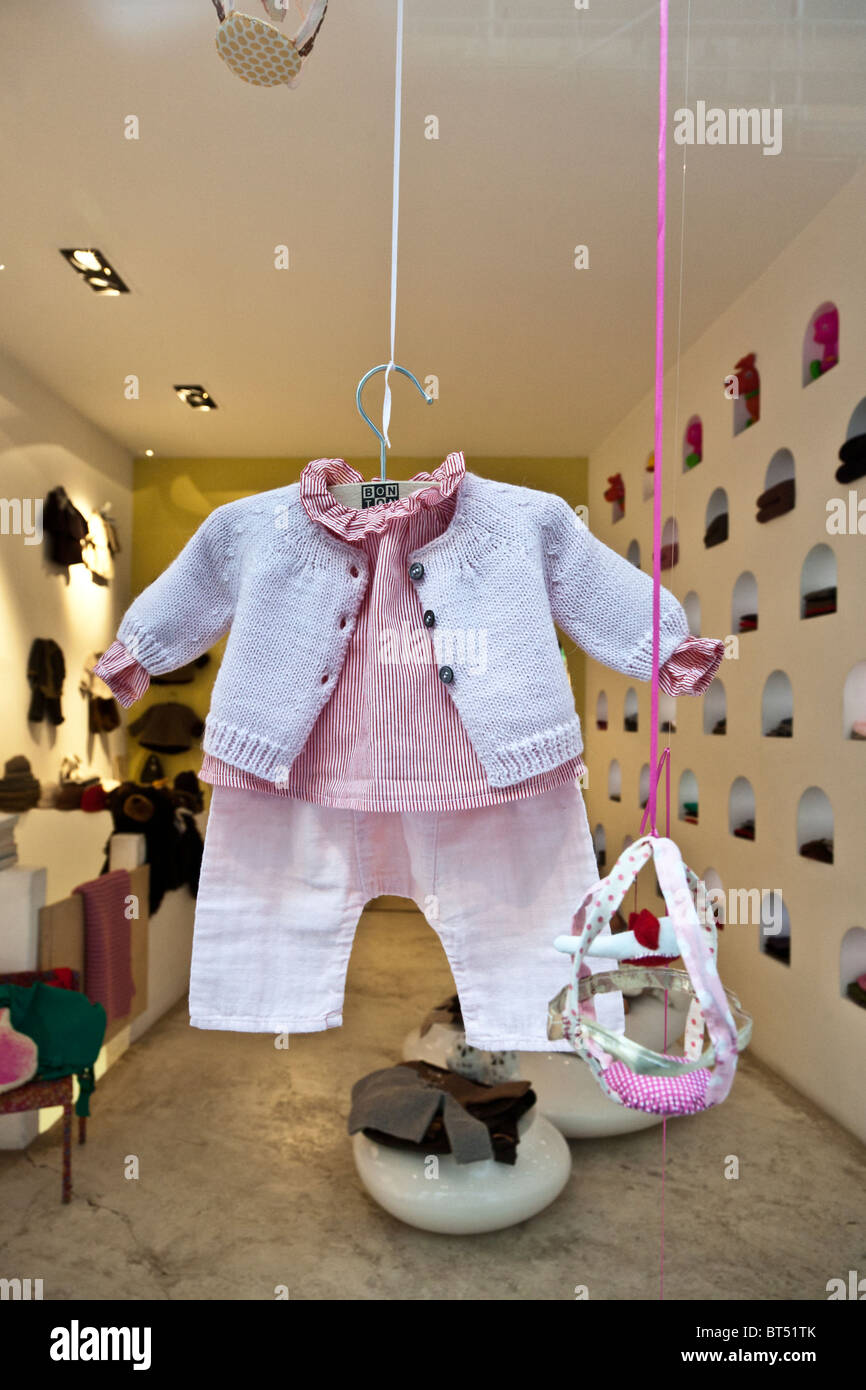 girly cute designer baby clothes suspended from ceiling hanging in