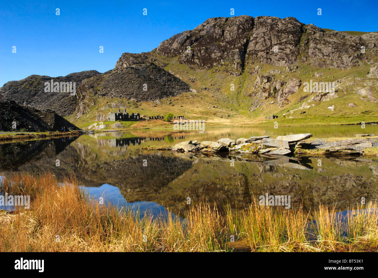 derelict stone and slate miners houses on the banks of a lake above ffestiniog in wales Stock Photo
